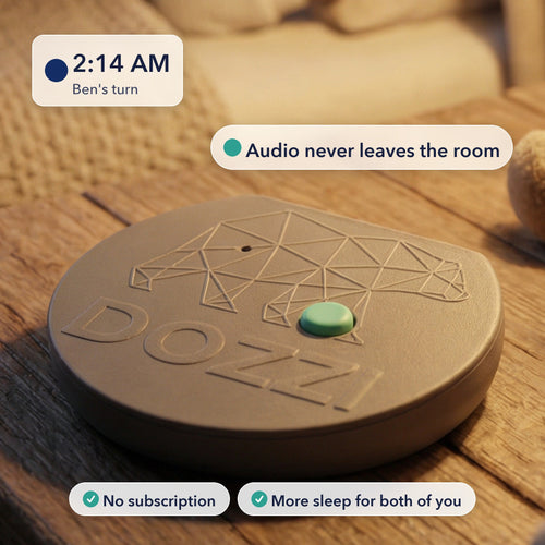 The Dozzi Base, a small round device with an embossed bear logo, on a wooden table in a warmly lit nursery